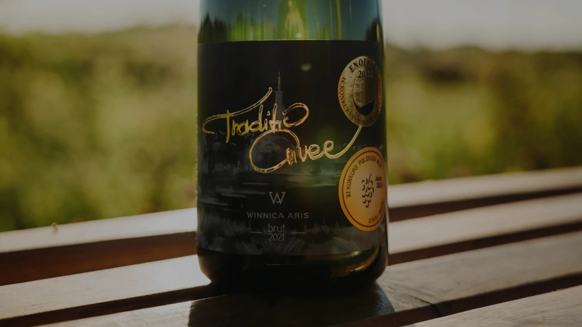 Zbliżenie na etykietę butelki Traditio Cuvee z Winnicy Aris reprezentującej polskie wina musujące wytwarzane metodą tradycyjną.